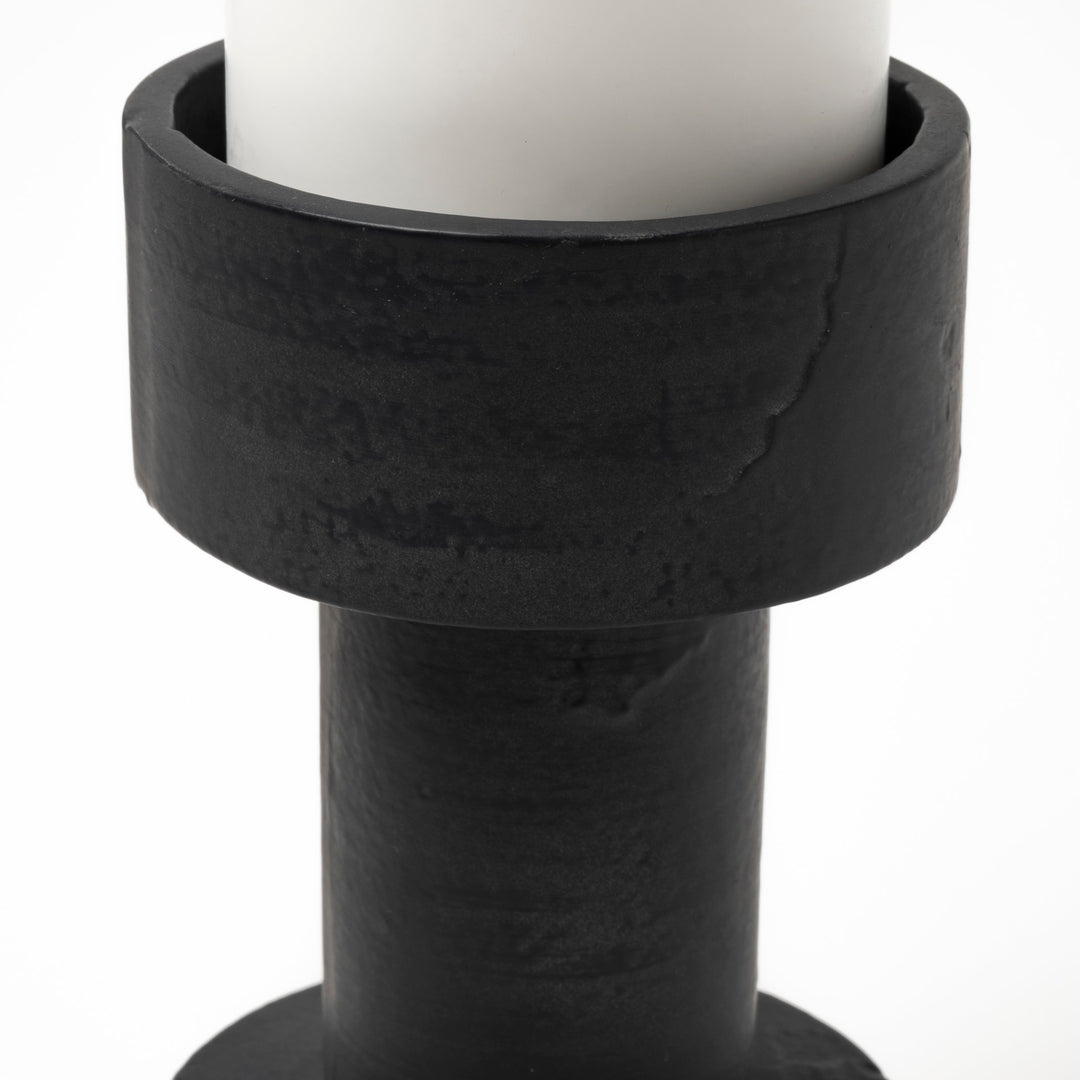 Black candle holder with a white candle 
