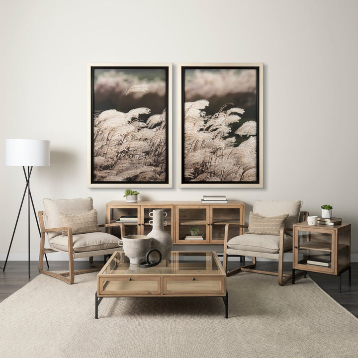 Modern living room with wooden furniture, glass coffee table, and framed artwork on the wall.