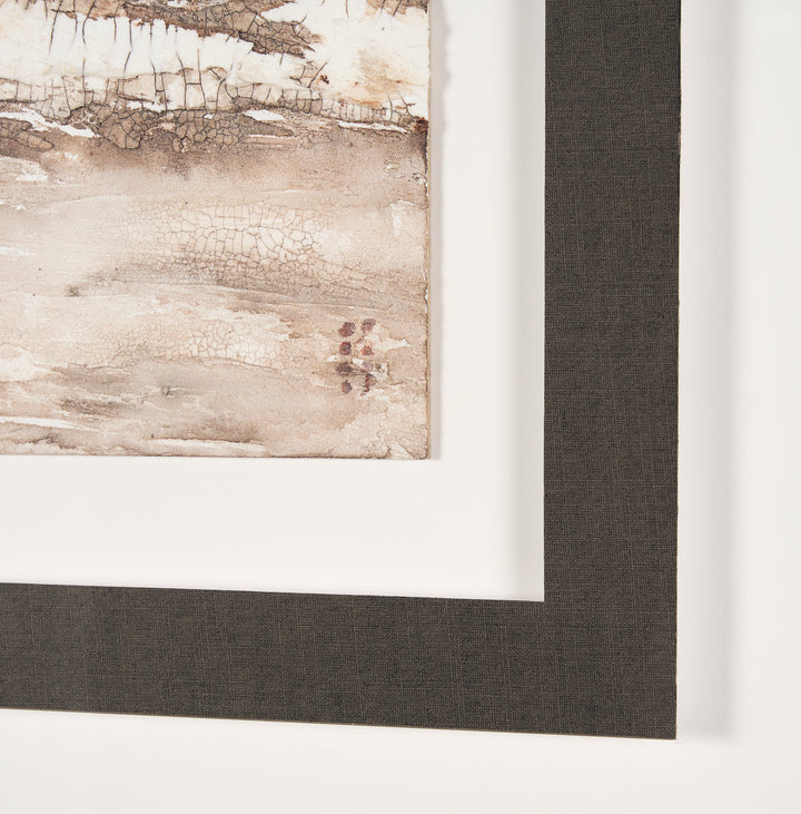 Close-up of a framed abstract painting with a textured border.