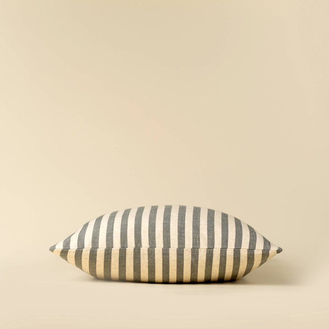 Striped pillow with blue and beige pattern on a beige background