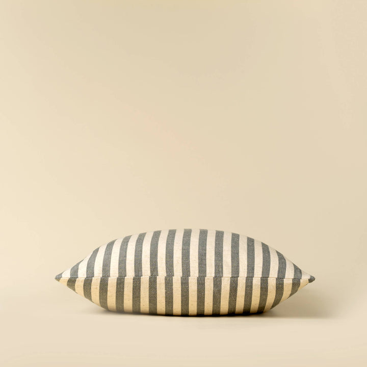 Striped pillow with blue and beige pattern on a beige background