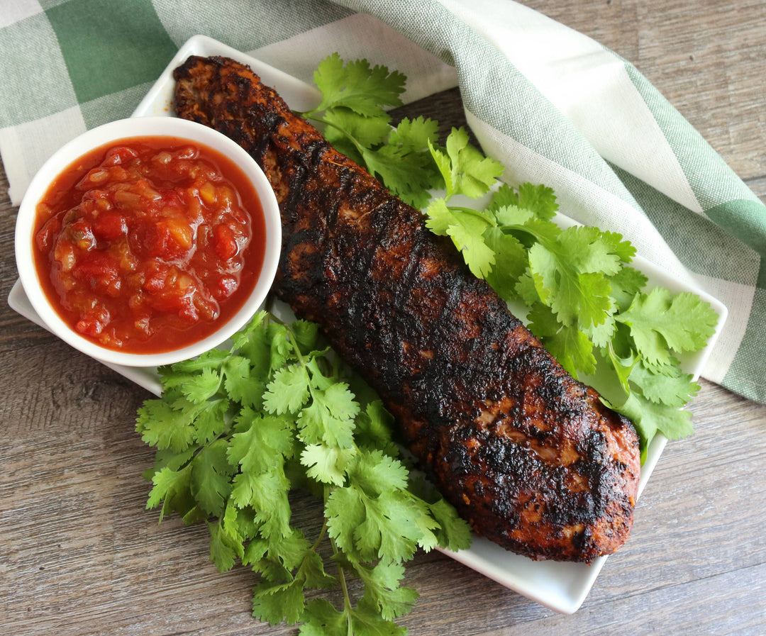 Grilled skewer with salsa and cilantro on a wooden surface