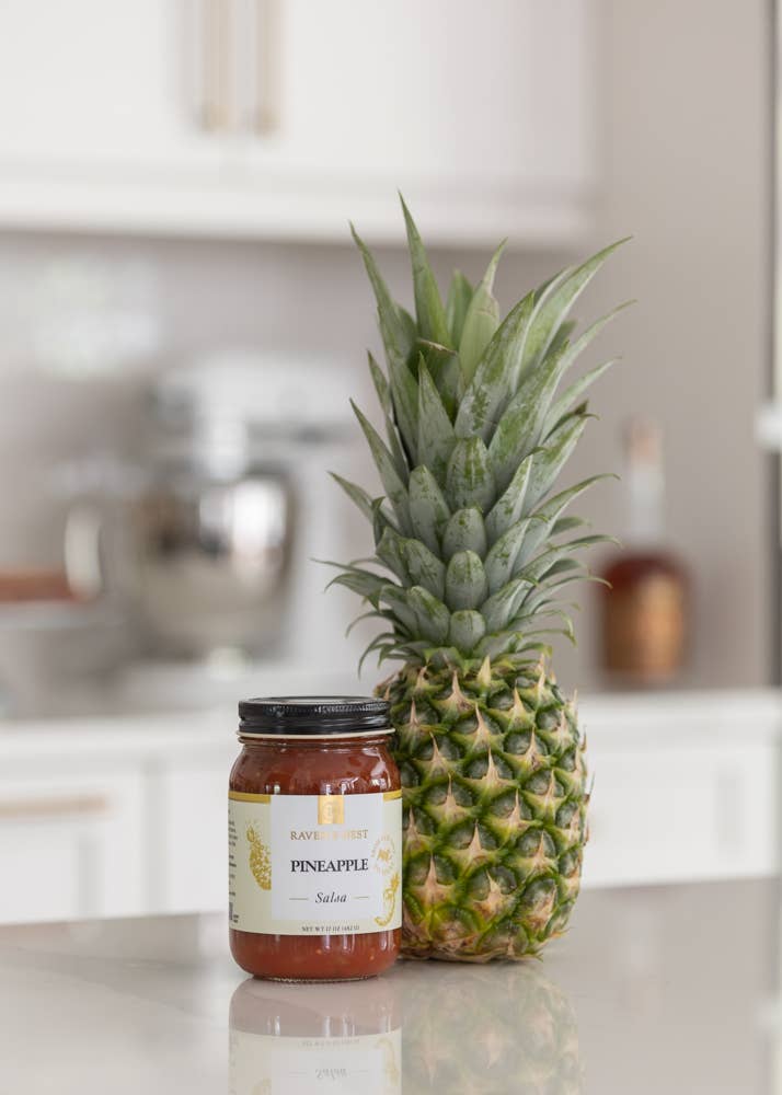Jar of pineapple salad and a pineapple on a kitchen counter.
