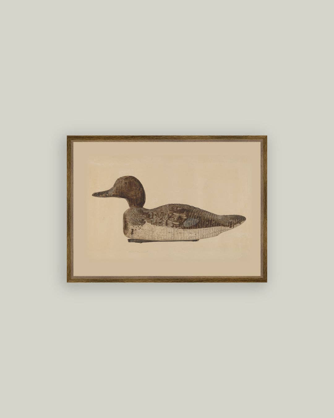 Framed artwork of a duck decoy with a beige background