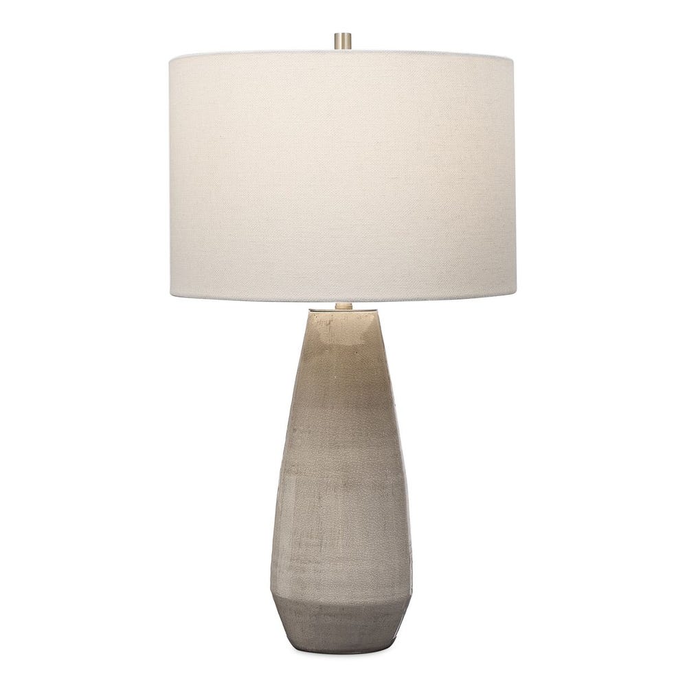 Simple yet stylish, this ceramic table lamp is finished in a crackled taupe-gray glaze with noticeable distressed details and antique brushed brass accents. The round hardback drum shade is a white linen fabric.