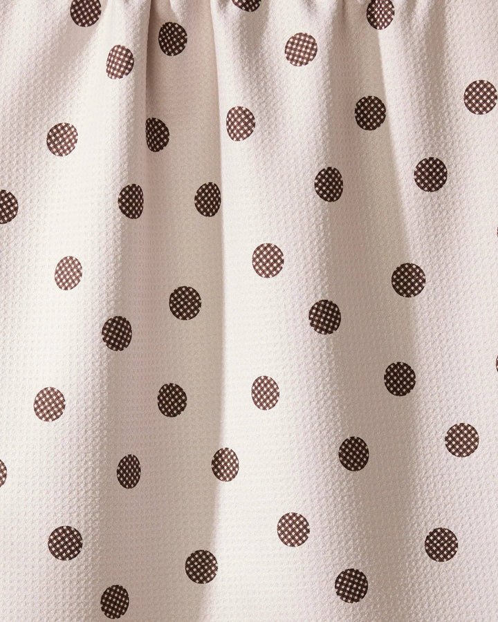 Close-up of a geometry towel with brown polka dots on a beige background