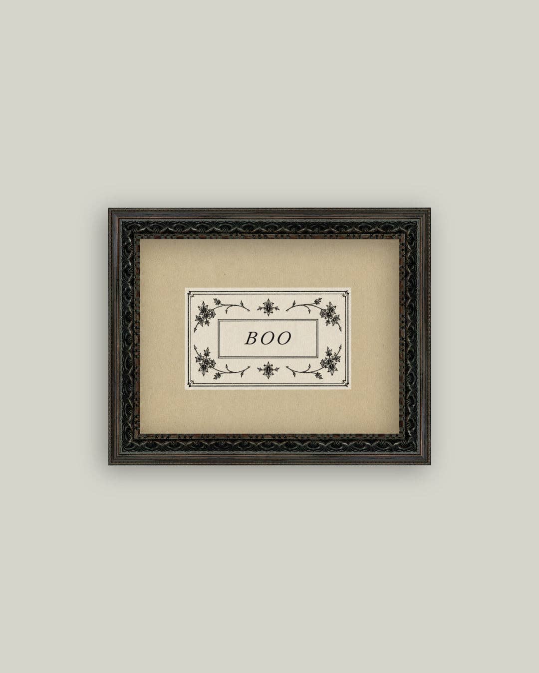 Framed artwork with 'BOO' text on a beige background