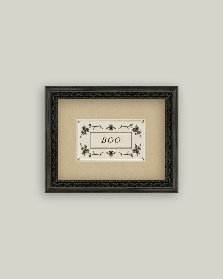 Framed artwork with 'BOO' text on a beige background