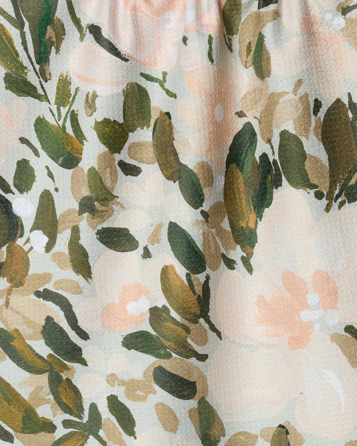 Floral patterned towel with green leaves and pink flowers on a beige background