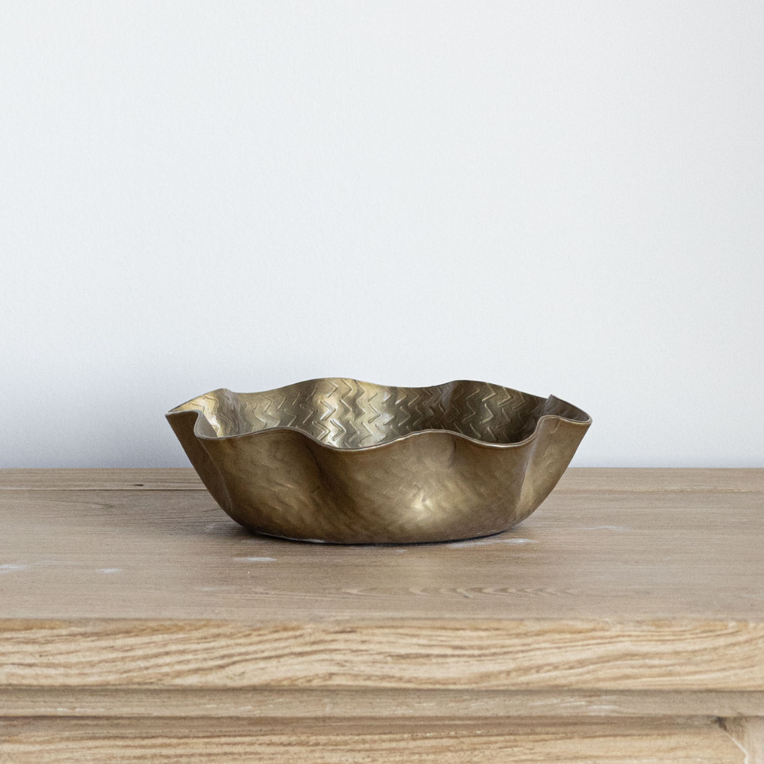 Brass bowl on a wooden surface with a white background