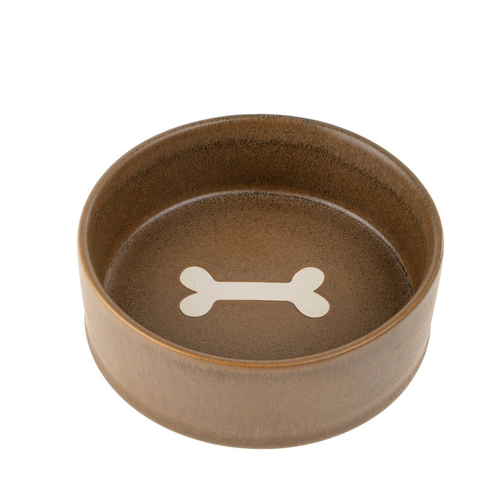 Brown ceramic dog bowl with a white bone design on a white background