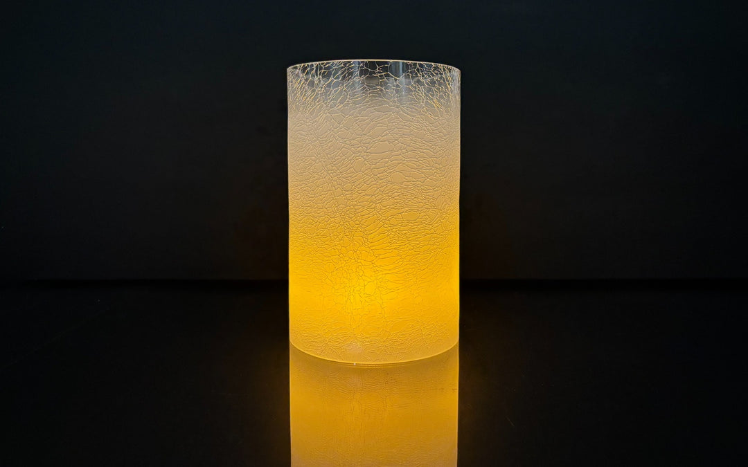 Cylindrical light fixture with textured surface glowing in a dark setting