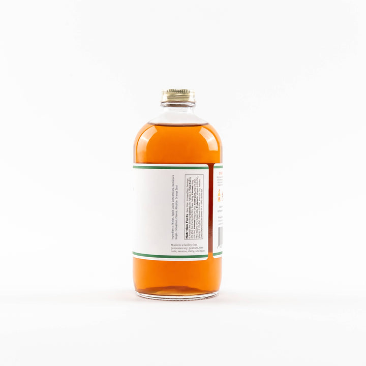 Bottle of orange liquid with a white label 