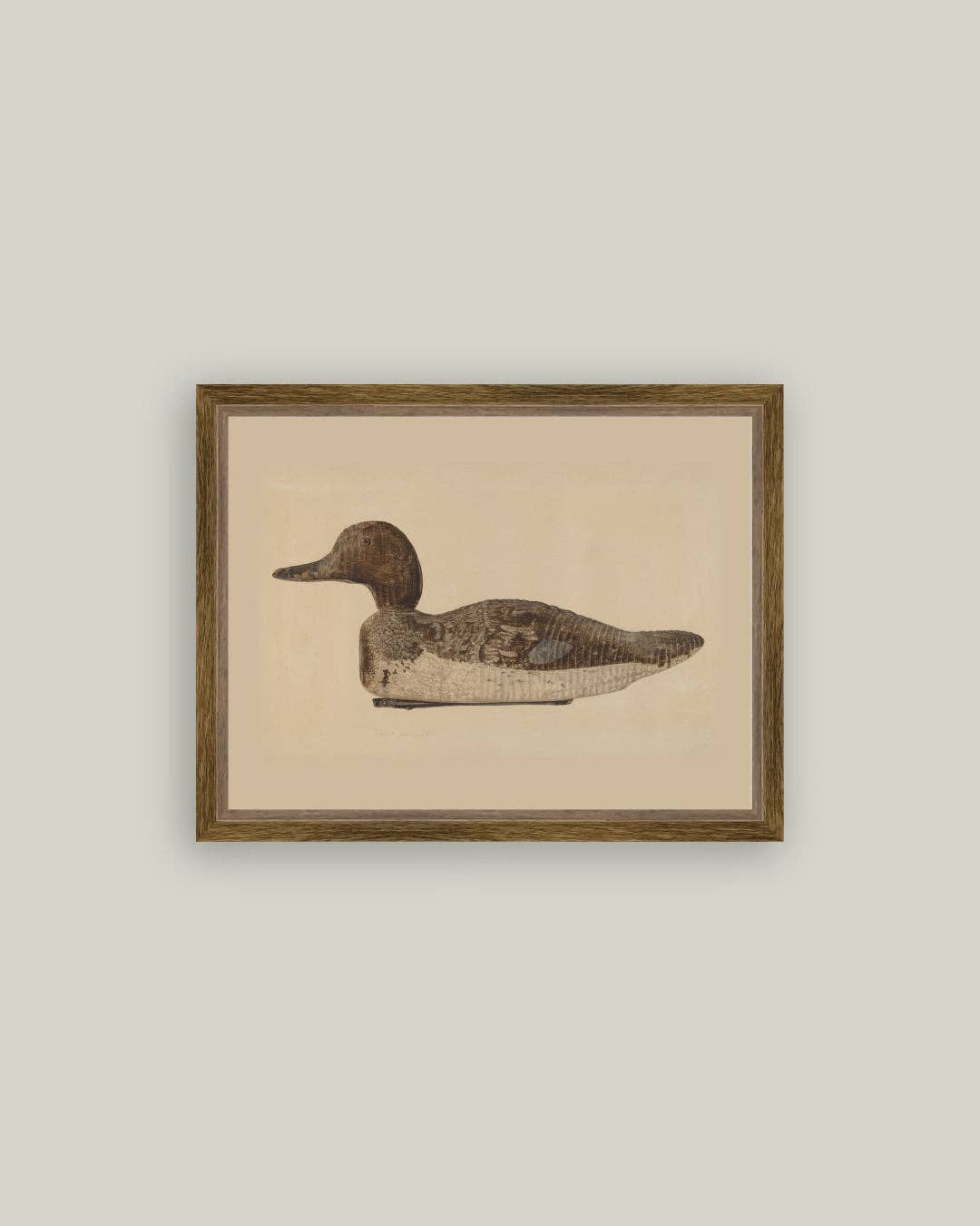 Framed artwork of a duck decoy with a beige background