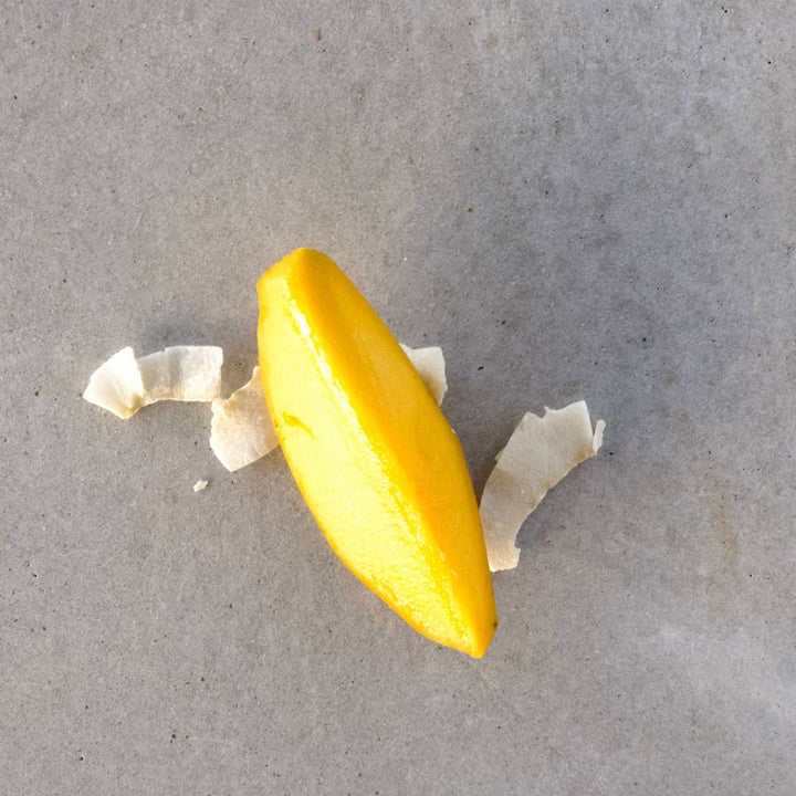 mango slice with peel on a gray surface