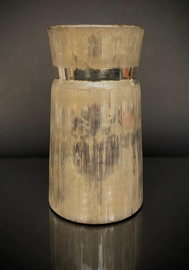 Textured cylindrical vase on a dark background
