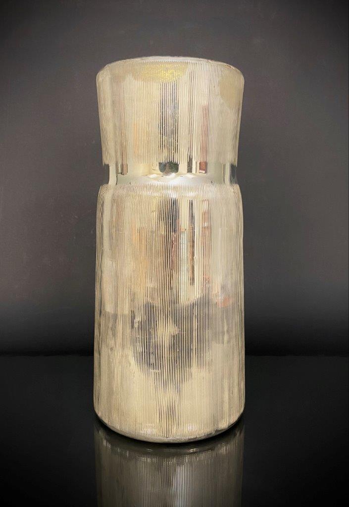 Textured cylindrical vase on a dark background