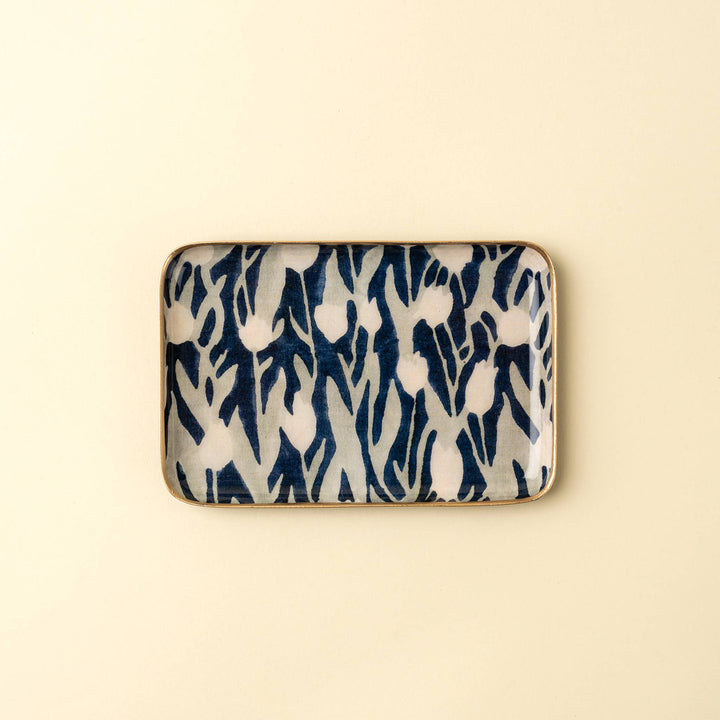 Rectangular ceramic dish with blue and white abstract pattern on a beige background