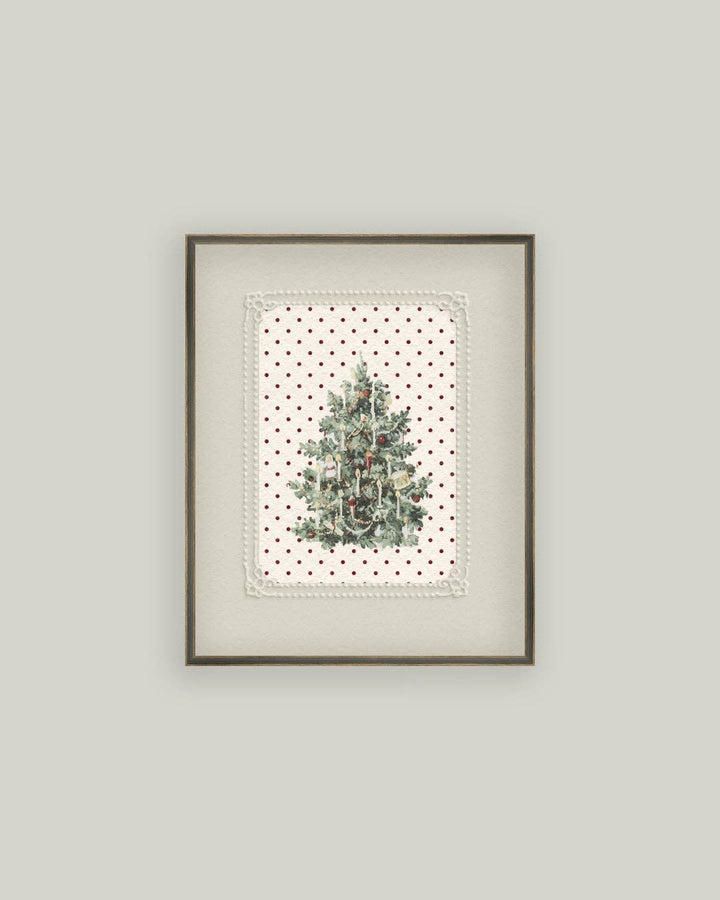 Framed artwork with a Christmas tree design on a polka dot background, mounted on a light gray wall.
