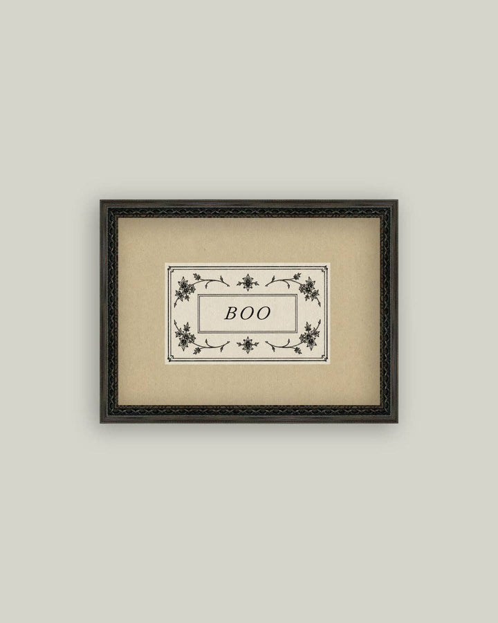 Framed artwork with 'BOO' text on a beige background
