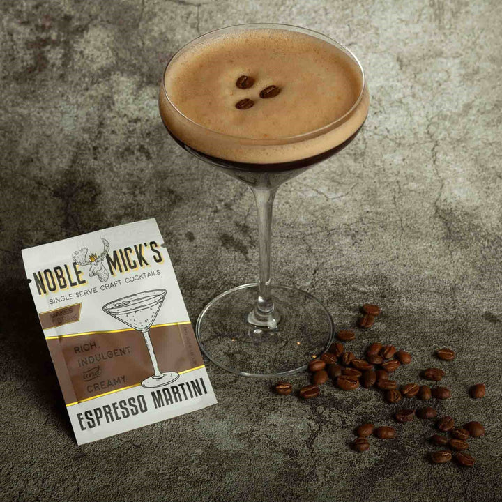 Espresso martini with coffee beans and a cocktail recipe card on a textured surface