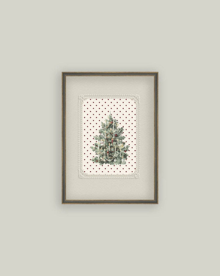 Framed artwork of a Christmas tree on a polka dot background against a light gray wall.