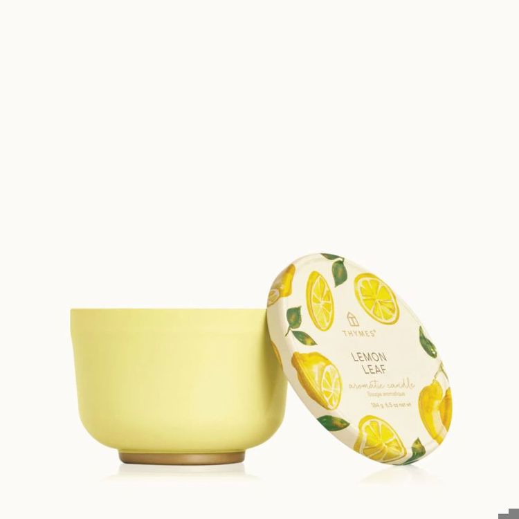Yellow candle with lemon leaf design on a white background