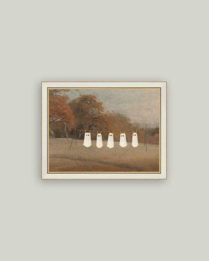 Framed artwork of four white ghosts in a park setting on a light gray wall.