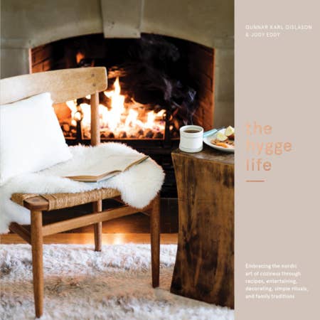 Cozy indoor scene with a fireplace, wooden bench, and table with a book and cup. the Hygge life book