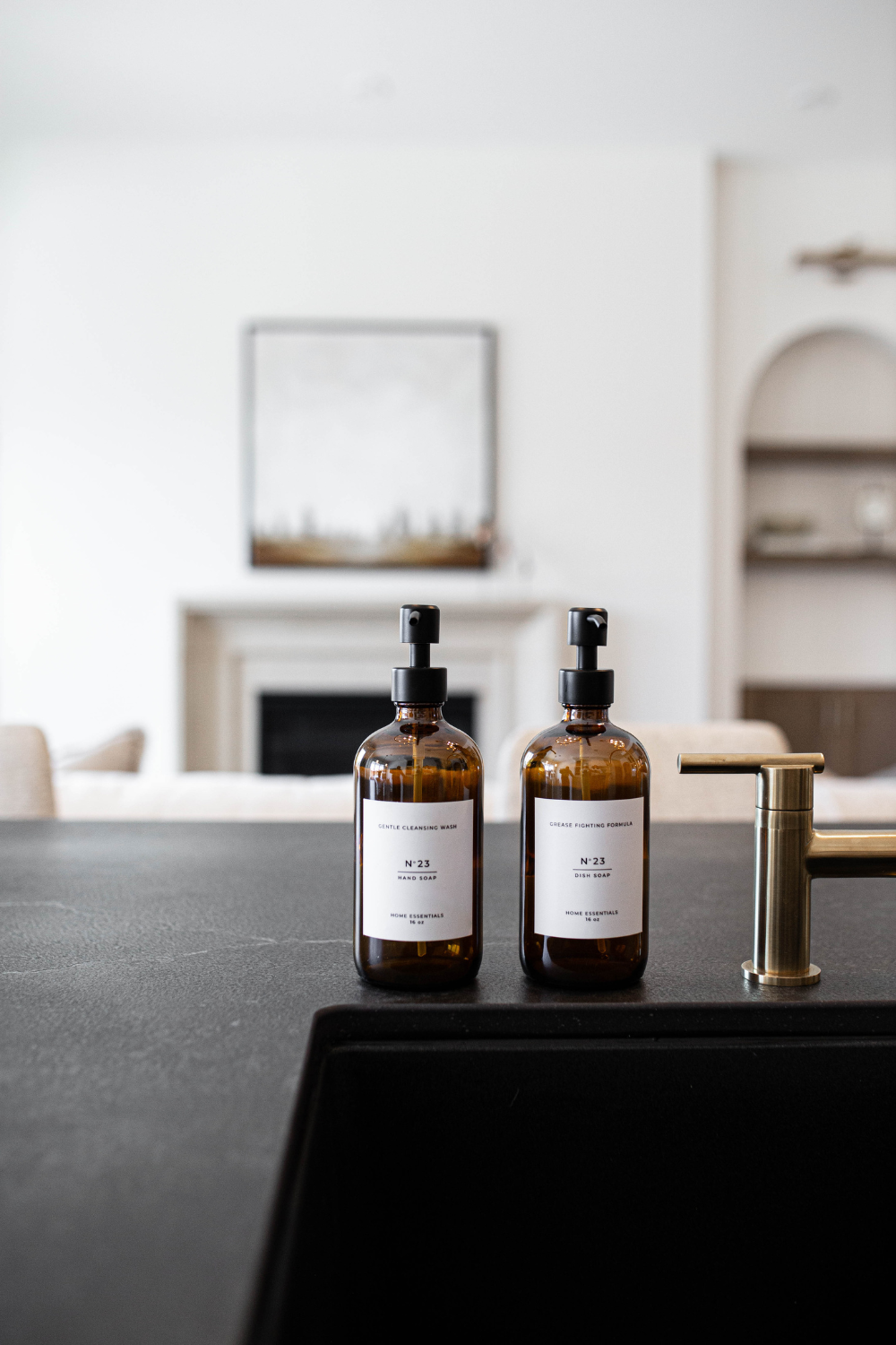 Two amber bottles with labels on a black countertop in a modern kitchen.