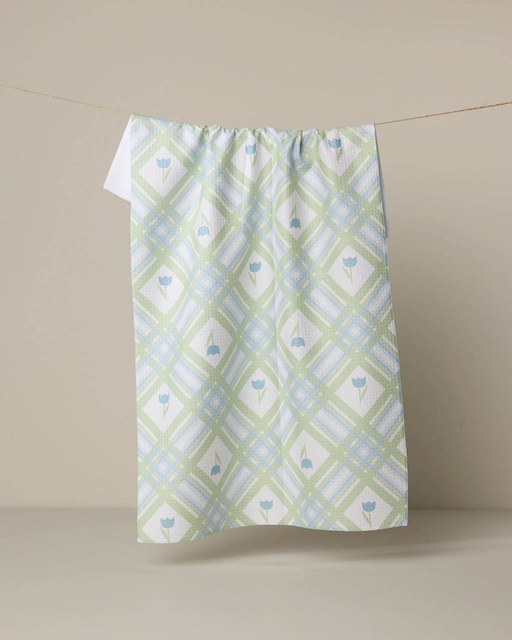 Green and white patterned towel hanging on a line against a beige background
