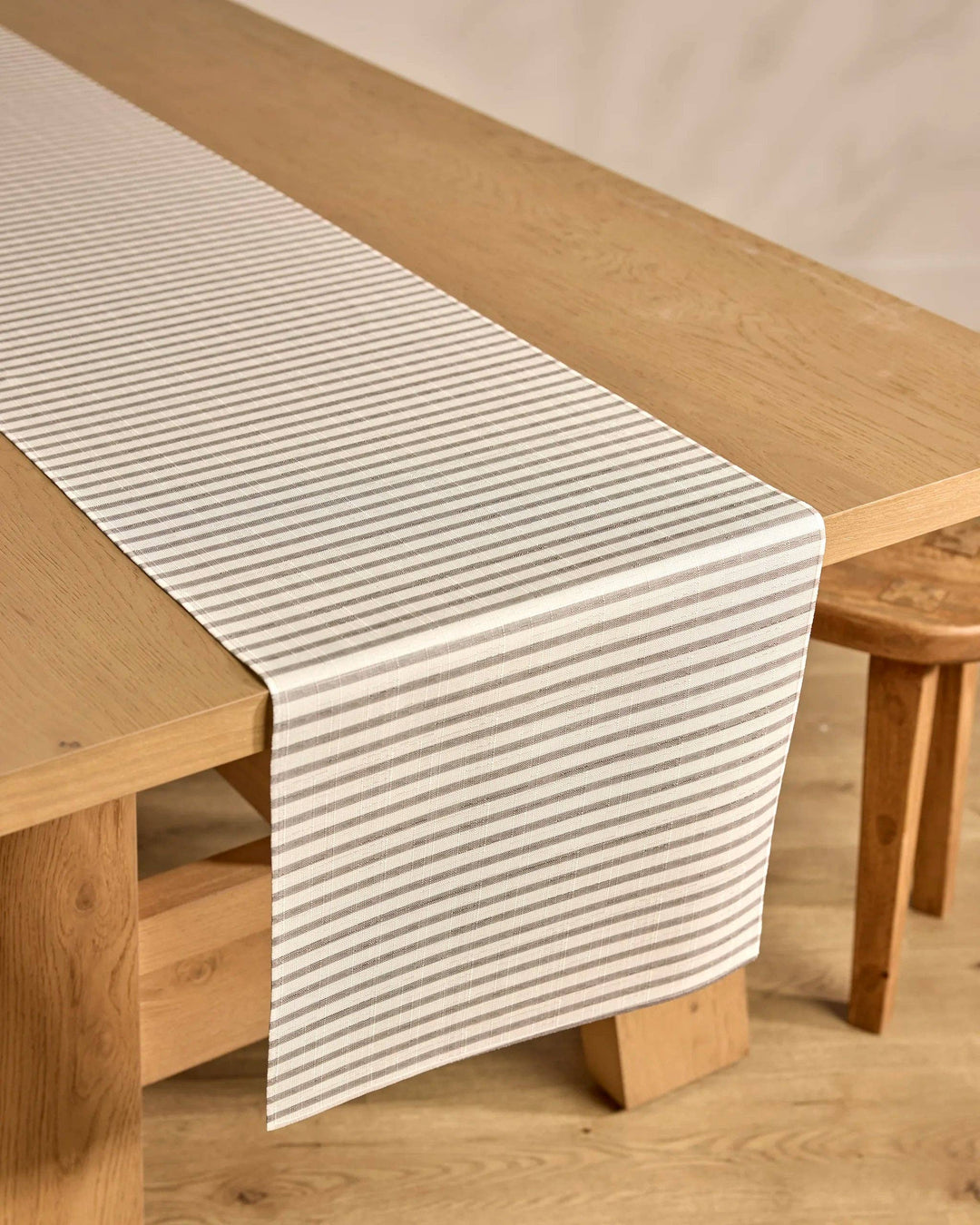 Striped table runner on a wooden table with a neutral background