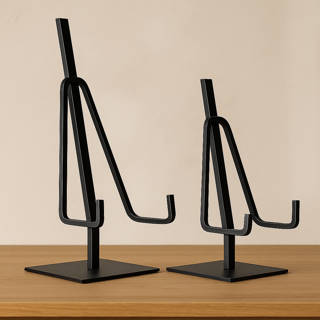 Two black metal earring stands on a wooden surface