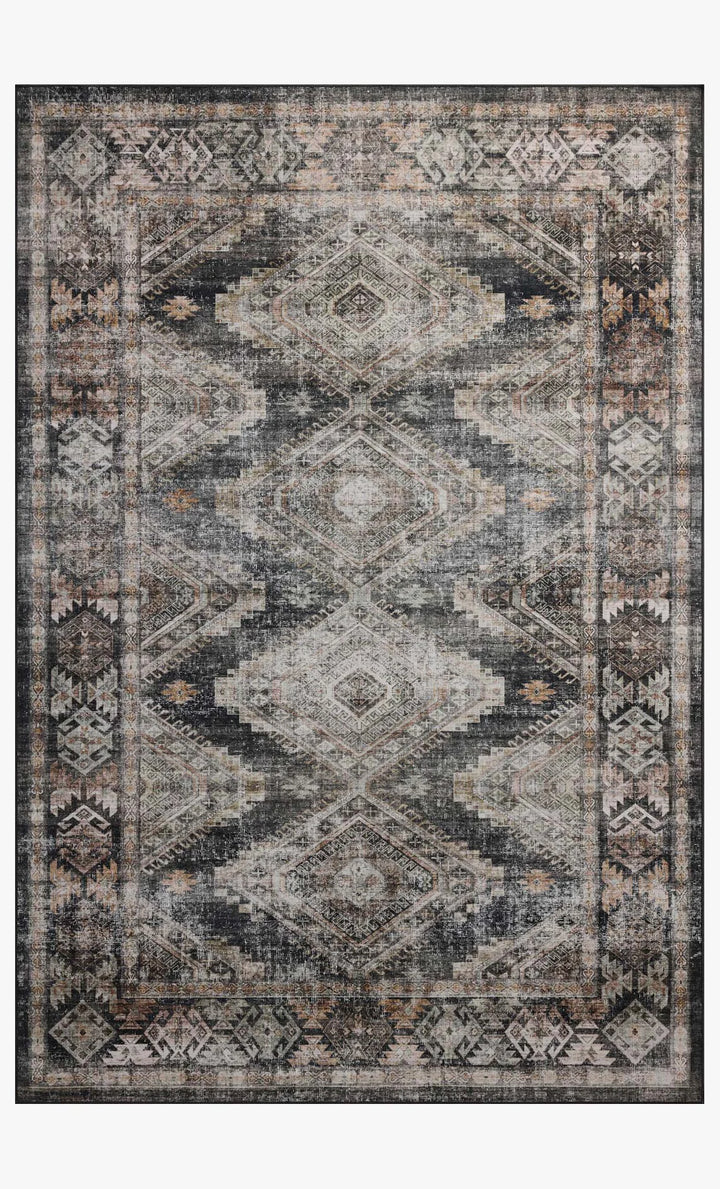 Patterned rug with geometric design in shades of gray, black, and beige on a white background