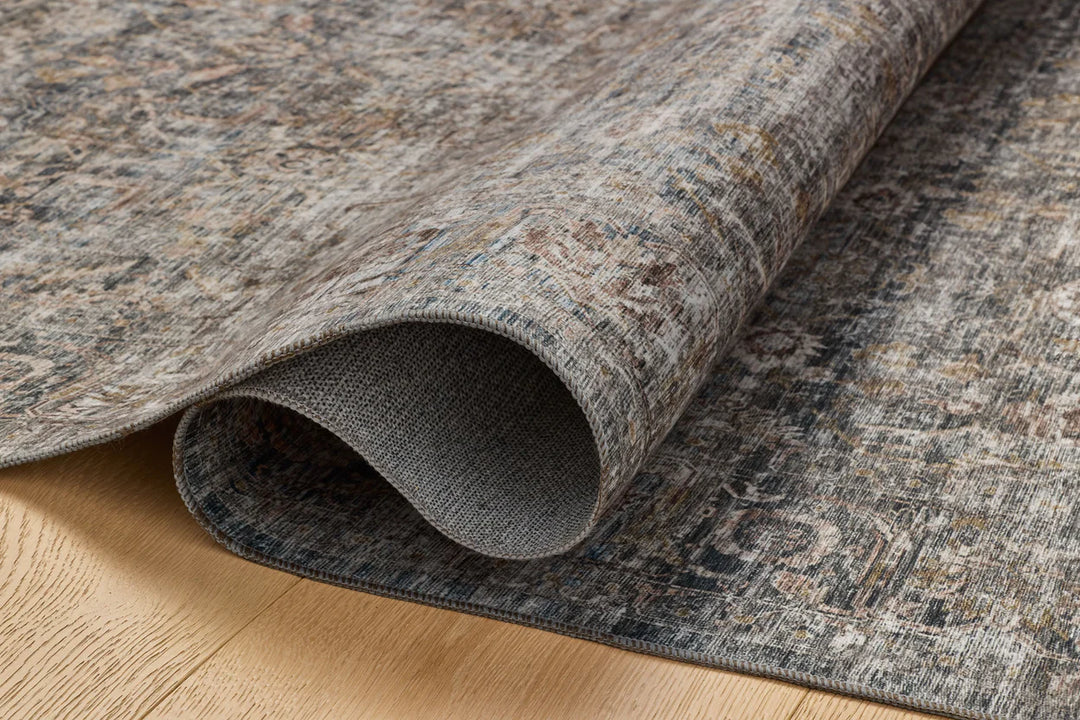 patterned rug with brown , blue, and burnt orange neutral tones