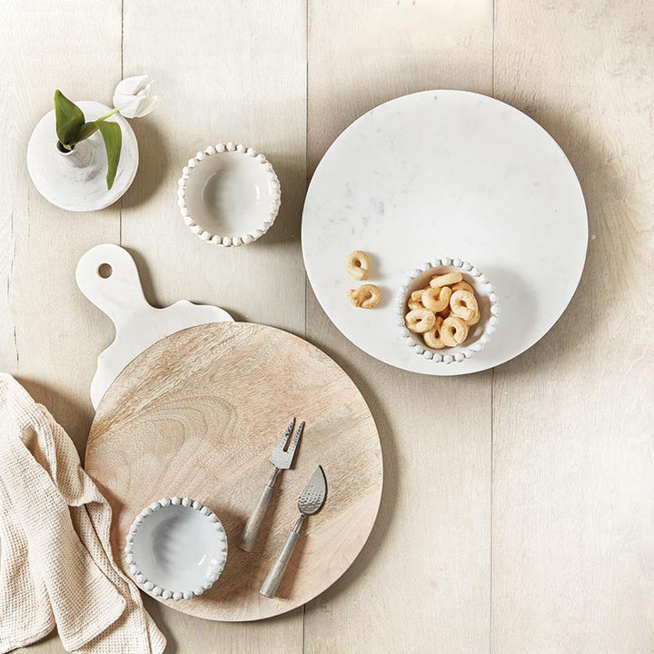 Dishes and cutlery on a wooden surface with a neutral background