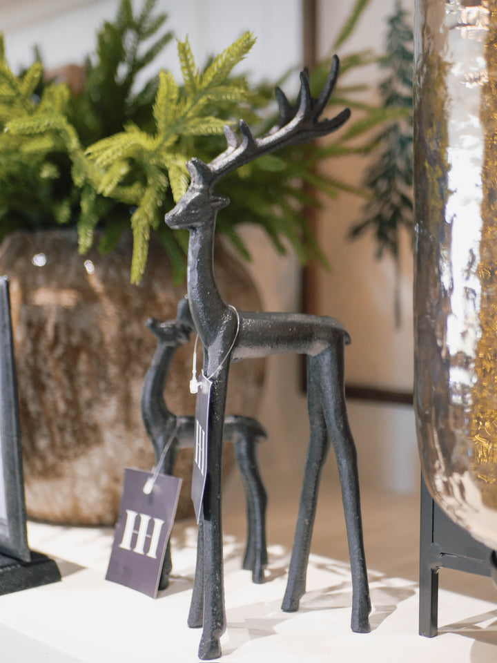 Decorative metal deer figure in front of green plants