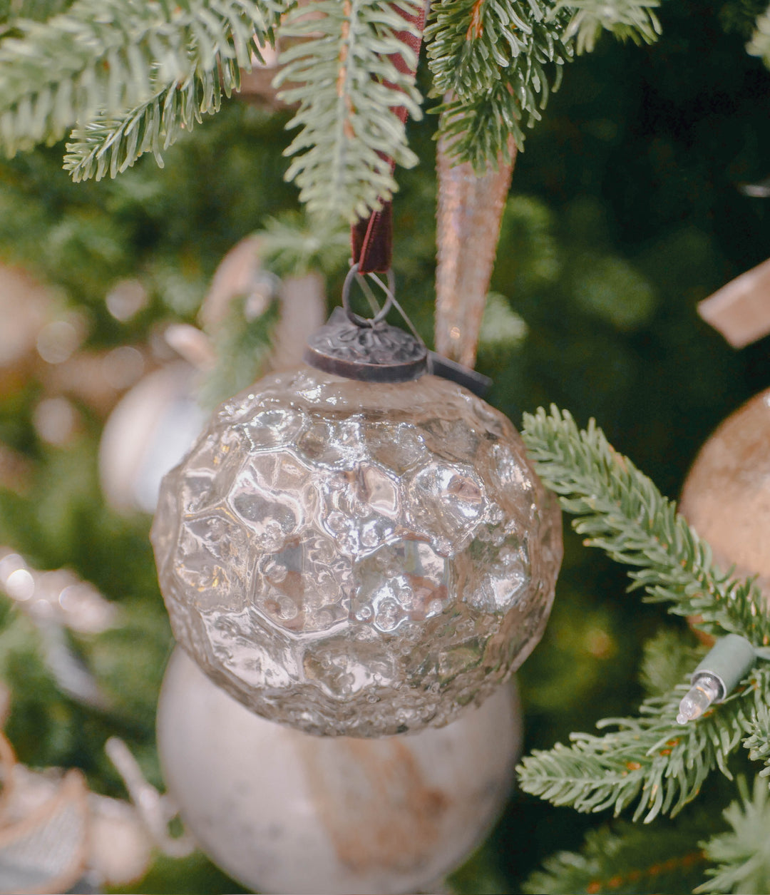 Decorative glass ornament hanging on a Christmas tree