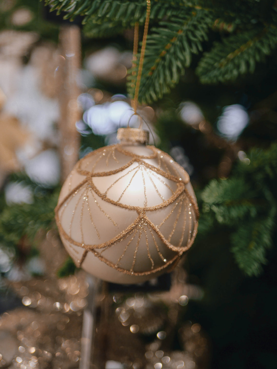 Decorative Christmas ornament with gold accents used for hanging on a tree.