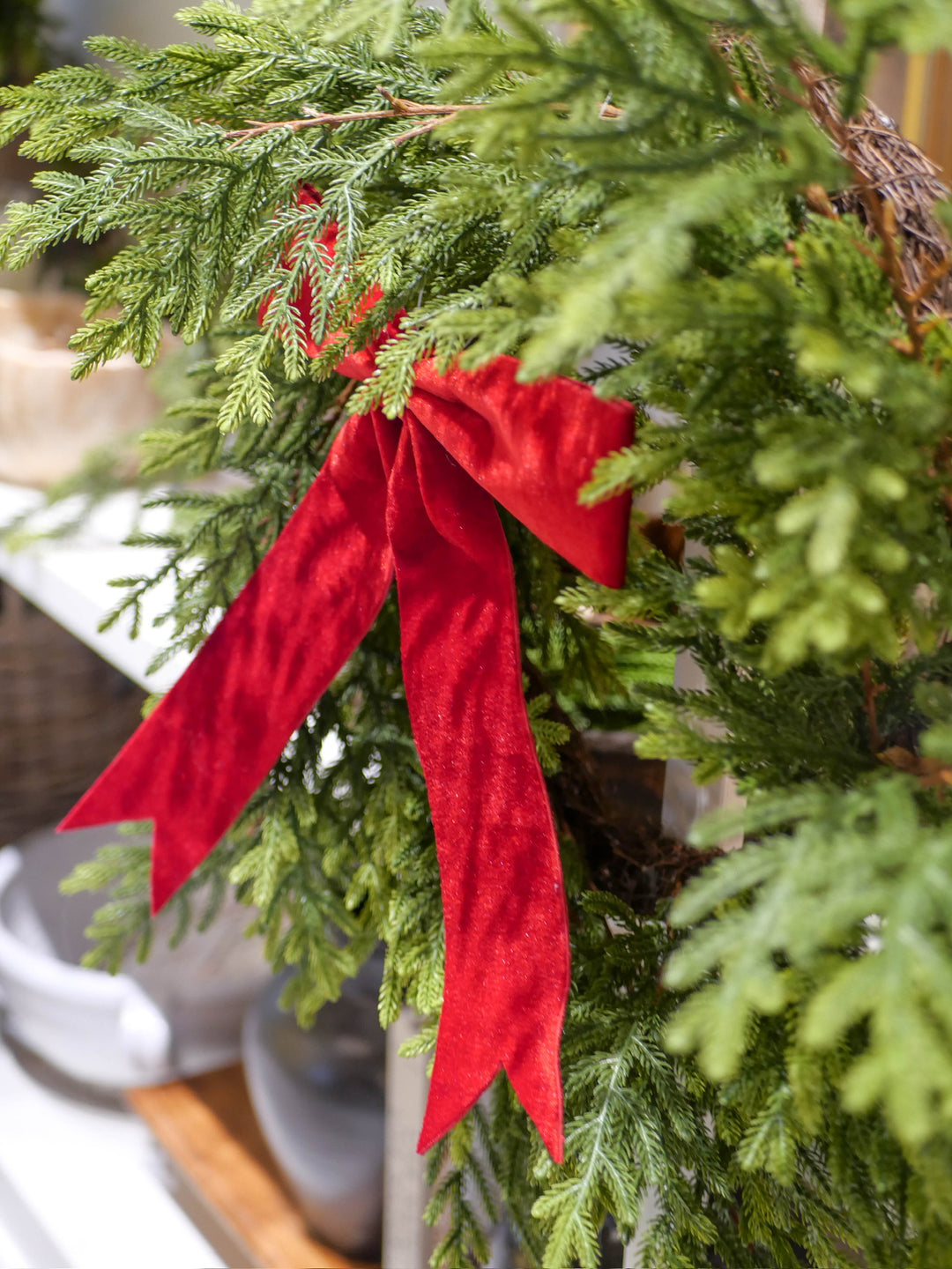 Green wreath with a red bow on a blurred background