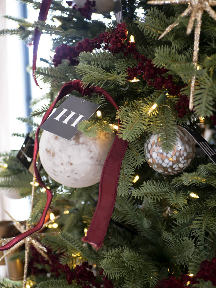 Decorative ornament with a red ribbon on a Christmas tree