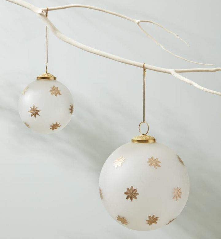 frosted glass ornament with gold cap and loop and painted gold starbursts