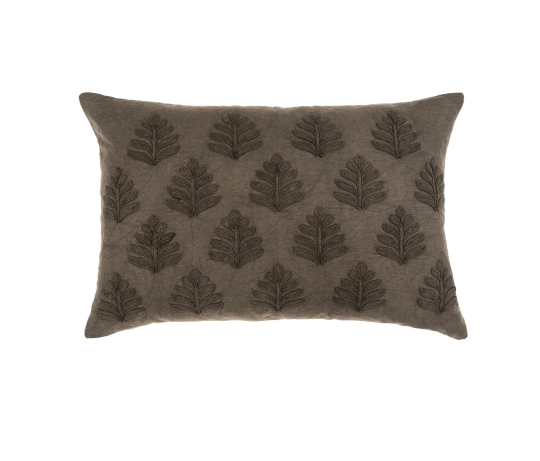 A rectangular throw pillow with a leaf pattern in warm charcoal and fog colors.