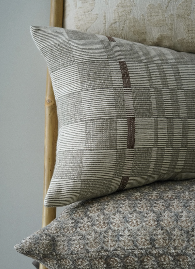 A beige and brown geometric patterned throw pillow.