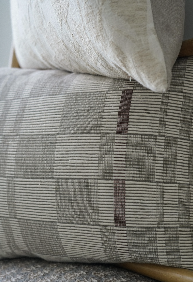 A beige and brown geometric patterned throw pillow.