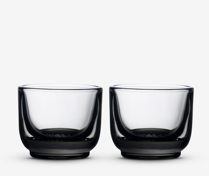 Two clear glass with gray tint coffee cups on a white background