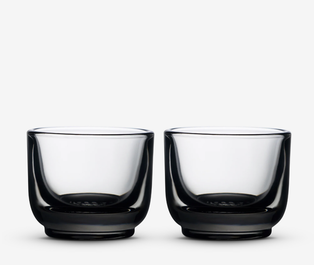Two smokey clear glass espresso cups on a white background