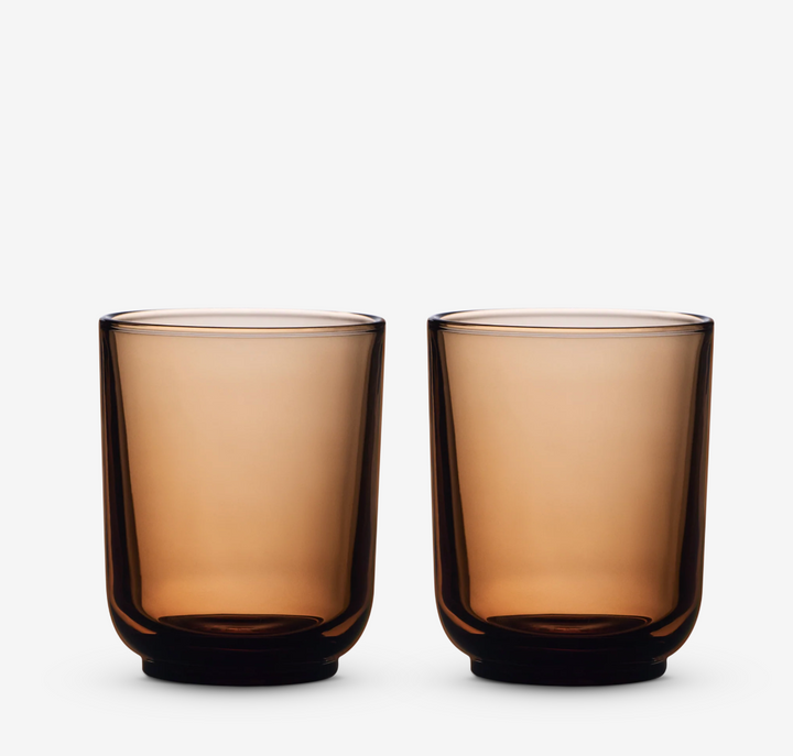 Two amber glass lattee coffee cups on a white background