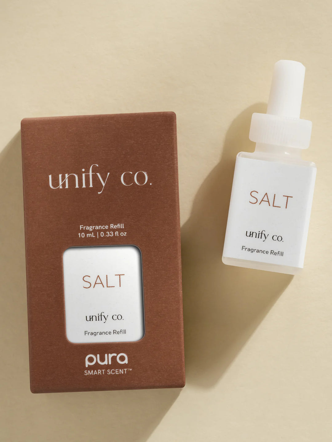 unify co. fragrance refill bottle and packaging on a beige background