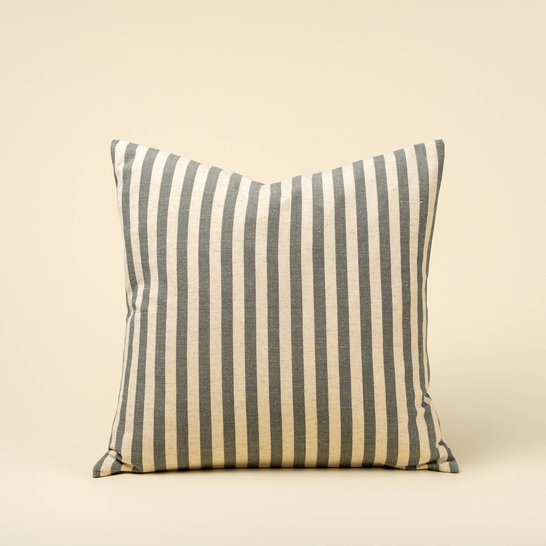 Striped pillow with blue and beige pattern on a beige background